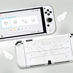 Könnte beinhalten: Eine weiße Handheld-Spielkonsole mit einem Bildschirm, der ein Menü mit verpixelten Symbolen anzeigt, und einer Controller-Seite mit einer Spritzengrafik. Die Rückseite zeigt ein Muster aus Engelsflügeln, einem Heiligenschein, Sternen und Noten.