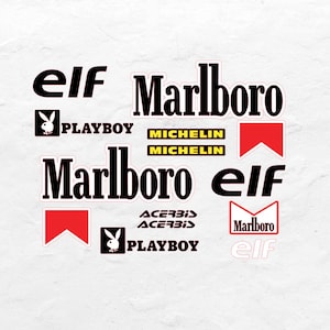 Può includere: Una collezione di adesivi con vari loghi, tra cui "elf", "Marlboro", "Playboy", "Michelin" e "Acerbis". Gli adesivi sono in nero, rosso e giallo, con sfondo bianco.