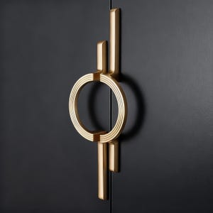 May include: A gold cabinet handle with a circular design and vertical accents. The handle is mounted on a black cabinet door. The circular part has three concentric rings. The handle has a modern, art deco style.