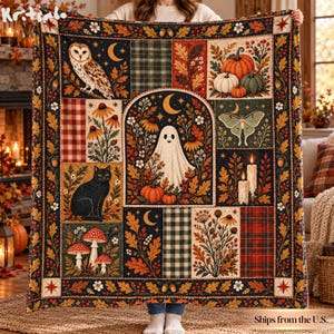Op de afbeelding: Een rechthoekige plaid met een patchworkontwerp met herfstthema-illustraties, waaronder een kerkuil, een zwarte kat, paddenstoelen, pompoenen, een spook, een mot en kaarsen, omlijst door een rand van eikenbladeren, bessen en eikels.
