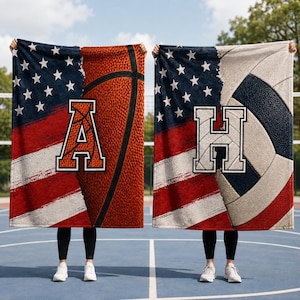 May include: Two rectangular blankets featuring a split design of the American flag on the left and a sports ball on the right. The left blanket displays a basketball and the letter A. The right blanket shows a volleyball and the letter H.