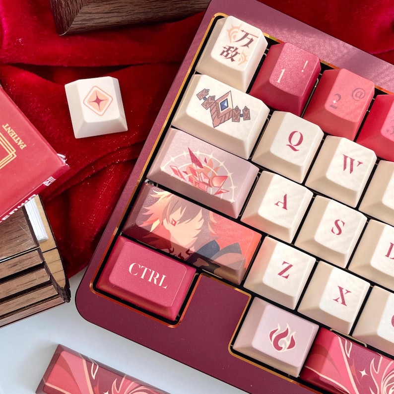 May include: A custom mechanical keyboard with a burgundy frame and cream-colored keycaps. Some keycaps feature illustrations and text, including a "CTRL" key. The keyboard rests on a red velvet surface, with additional keycaps visible.