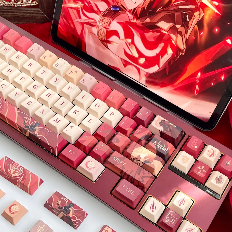 May include: A custom mechanical keyboard with a red and white color scheme. The keycaps feature various designs and text, including "SHIFT" and "CTRL". The keyboard is displayed with a tablet showing a red graphic.