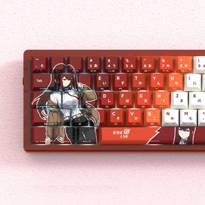 Könnte beinhalten: Eine rot-weiße mechanische Tastatur mit japanischen Schriftzeichen und Anime-Artwork auf den Tastenkappen. Die Tastatur hat ein kompaktes Layout und verfügt über ein individuelles Design mit einer Charakterillustration.