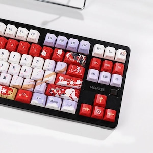 May include: A black mechanical keyboard featuring custom keycaps with a red, white, and purple color scheme. The keys display various floral patterns, anime-style character illustrations, and the brand name MCHOSE printed in white on the frame.