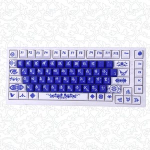 May include: A white mechanical keyboard featuring blue keycaps with white Chinese characters and standard QWERTY letters. The white keys are decorated with blue floral patterns, butterflies, and intricate designs. The layout includes function keys.
