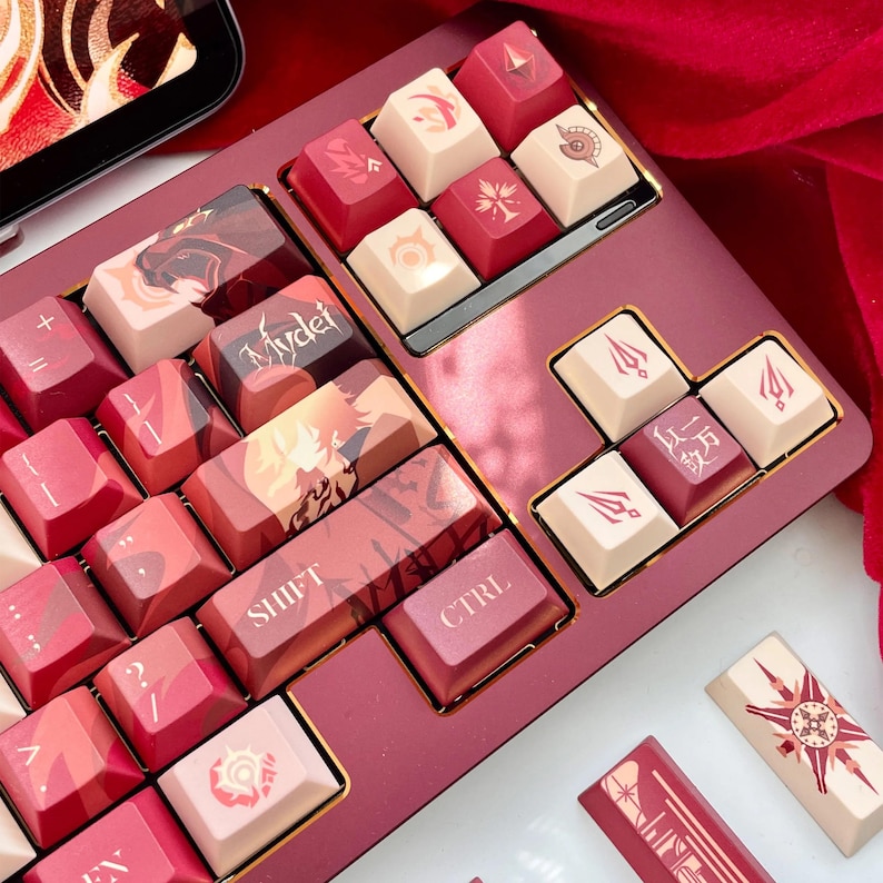 May include: A custom keyboard with red and cream-colored keycaps. The keycaps feature various designs and symbols, including the words "SHIFT" and "CTRL". The keyboard has a red base with gold accents and is set against a red fabric background.
