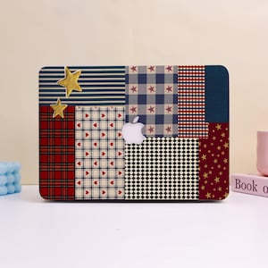 May include: A laptop case with a patchwork design featuring various patterns, including stripes, plaid, hearts, stars, and a black and white checkerboard. Two gold star embellishments are visible. The Apple logo is in the center.