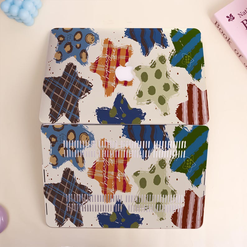 May include: A laptop case with a colorful star pattern. The design features stars in various styles, including plaid, polka dots, and stripes, in shades of brown, orange, blue, and green. The case has a white background with a few small dots.