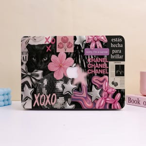 May include: A decorative laptop case featuring a black cat, disco ball, pink flowers, silver stars, and the text "XOXO". The case also includes the text "sorry, I'm a cancer" and "CHANEL".