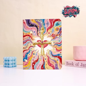 Peut inclure: Un journal coloré avec un motif de croix et de cœur doré. La couverture présente un mélange vibrant de teintes arc-en-ciel, d'étoiles et de tourbillons. Le journal a un code couleur rose et rouge, avec le mot "SUPKAM".
