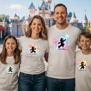 A happy family of four standing in front of a theme park castle wearing white t-shirts with different custom Mario galaxy designs and "Super Family" text.