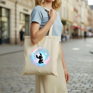 "Ready to press DTF transfer featuring a galaxy-themed Stitch silhouette with glowing colorful aura for custom tote bag printing."