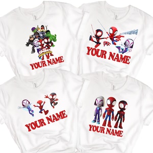 May include: White t-shirts with colourful cartoon graphics of Spider-Man and friends. Each shirt has the text "YOUR NAME" in red, with different character arrangements. These shirts are likely for children.