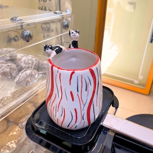 Puede incluir: Juego de tres tazas de cerámica con acabado mate moteado. Las tazas son de color crema, gris claro y gris oscuro. Cada taza tiene un diseño simple y minimalista, ideal para café o té.