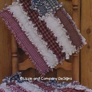 May include: A red and white checkered rag quilt with a white ruffled edge. The quilt is folded and draped over a wooden chair. The quilt is made of fabric scraps and has a rustic, handmade look.