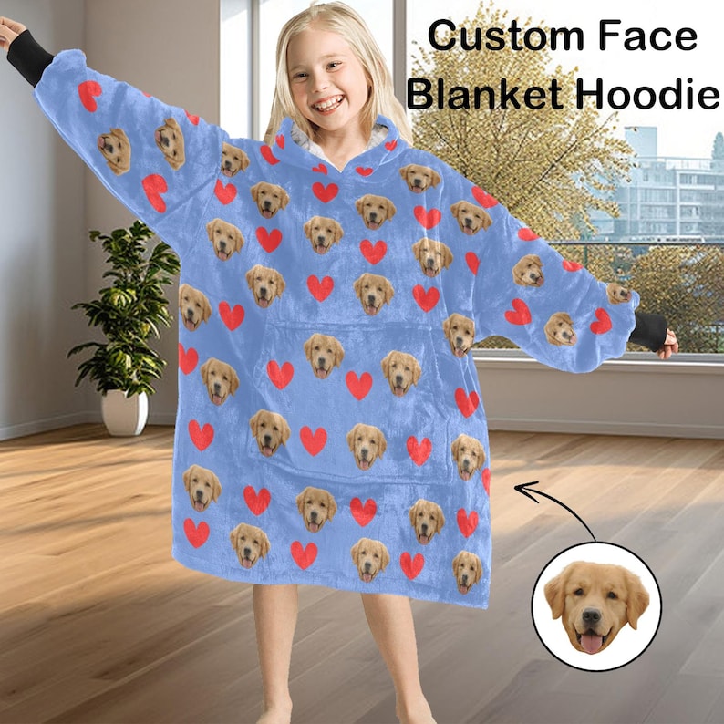 Pu&ograve; includere: Una felpa con cappuccio a coperta azzurra con un motivo ripetuto di facce di cane e cuori rossi. La felpa con cappuccio ha un'ampia tasca frontale e polsini neri. Il testo sull'immagine recita "Custom Face Blanket Hoodie."