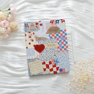 Peut inclure: Un journal décoratif avec un motif patchwork présentant des éléments patriotiques et religieux. La couverture comprend le texte « Free in Jesus », un cœur rouge et le drapeau américain. Le journal est décoré de motifs floraux et d'étoiles.