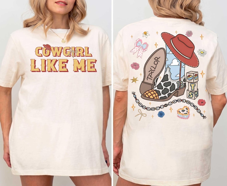 May include: An off-white t-shirt featuring the text COWGIRL LIKE ME on the front. The back displays a graphic of a cow-print cowboy boot, a red hat, blocks with the letters T S, and a beaded string with the text THE ERAS TOUR.