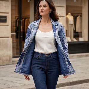 May include: A blue blazer featuring a textured patchwork pattern in various shades of blue and white, worn over a plain white camisole and dark blue denim jeans. The blazer has a notched lapel, long sleeves, and a solid dark blue interior lining.