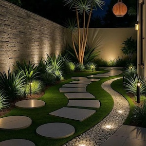 May include: A garden at night with a winding stone path through green grass. The path is lit by small lights, and the garden features lush greenery, including palm trees and decorative lighting.