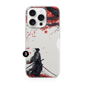 May include: Clear phone case featuring a Japanese-inspired design. The artwork depicts a samurai warrior with two swords, set against a backdrop of red leaves and a full moon. The case has a clear border.