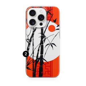 May include: A phone case featuring a Japanese-inspired design. The case has a clear border and a vibrant orange background. Black bamboo stalks and leaves are set against a white circle, with a red sun and flying birds. The number "2" is visible.