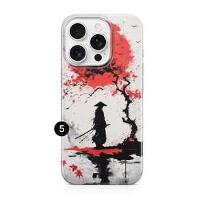 May include: Clear phone case featuring a Japanese-inspired design. The artwork depicts a silhouetted samurai warrior with two swords, standing before a red tree and a red sun. The background is white with black accents.