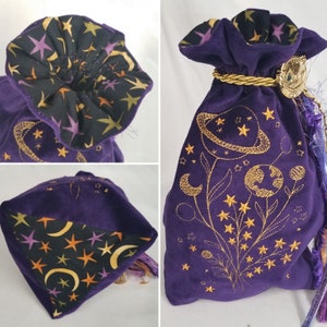 May include: A purple velvet drawstring bag with gold embroidered celestial designs, including planets, stars, and crescent moons. The bag's interior lining is black with a pattern of stars and moons. A gold cord and tassel complete the design.