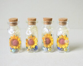 4   paper flowers  and dried flowers  in glass bottles