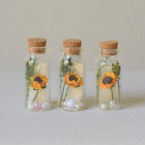 3 girasoli di carta e fiori secchi in bottiglie di vetro