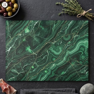 May include: Rectangular green cutting board with a malachite design and gold-colored veining. The board is surrounded by olives, herbs, and other food items, suggesting a culinary theme. The board's dimensions are not visible.