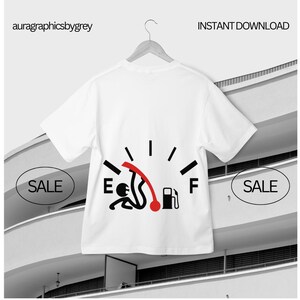 Puede incluir: Camiseta blanca con un diseño de indicador de combustible negro y rojo, que indica un nivel de combustible bajo con una figura de palo. La camiseta está colgada de una percha de madera. Las letras "E" y "F" son visibles.