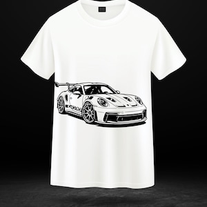 Peut inclure: T-shirt blanc avec une illustration en noir et blanc d'une voiture de sport. La voiture a un aileron et des roues détaillées. Le t-shirt est de style col rond.