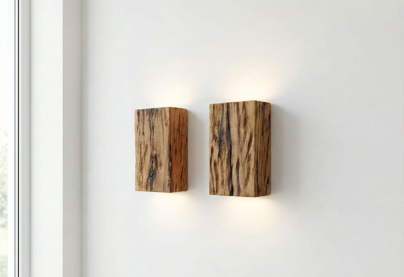 May include: Two wooden wall sconces with a natural, textured appearance. The sconces are rectangular and emit a warm light from the bottom. The wood has a mix of light and dark brown tones, creating a rustic aesthetic.
