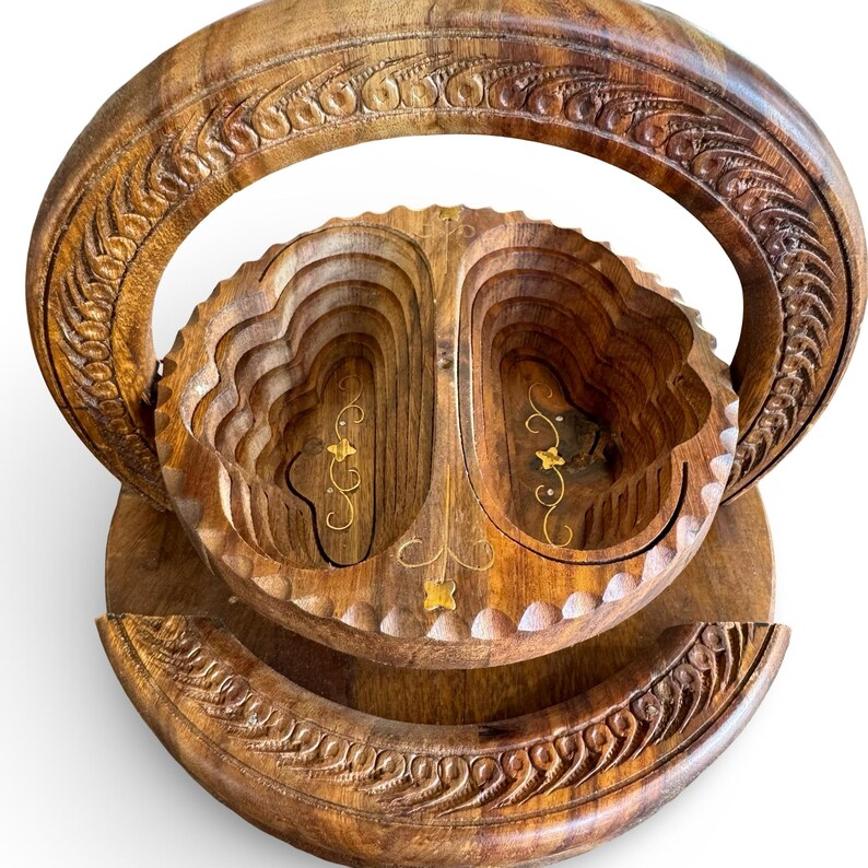Peut inclure: Un panier &agrave; fruits en bois avec une poign&eacute;e et une base sculpt&eacute;es. Le panier a un design en couches avec des accents dor&eacute;s. Le bois a une teinte marron chaude et la poign&eacute;e et la base pr&eacute;sentent des sculptures complexes.
