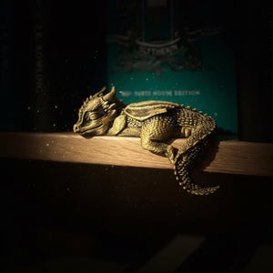 Figurka śpiącego smoka na półce: dekoracja kącika książkowego w stylu gotyckiego fantasy