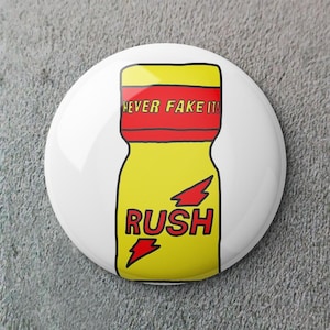 May include: A round white button badge with a yellow bottle design, red accents, and the text "NEVER FAKE IT!" and "RUSH". The bottle has two lightning bolt graphics.