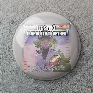 May include: A round, white button with a colorful graphic. The graphic features a cartoon character with green hair and the text "LET'S TAKE IBUPROFEN TOGETHER". Additional Japanese text is also present.