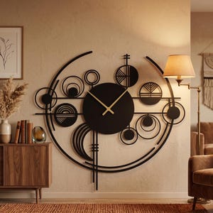 May include: A large, black metal wall clock with a modern, geometric design. The clock features a circular face with gold-colored hands and is surrounded by various sized circles and semi-circles. The clock is mounted on a beige wall.