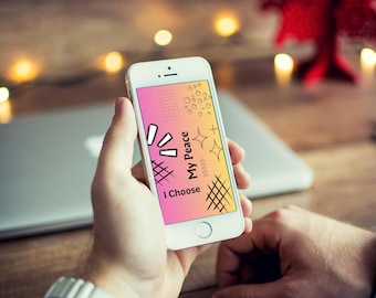 Może przedstawiać: Biały smartfon z ekranem o gradiencie od różowego do żółtego, czarnymi wzorami graficznymi oraz napisem "I Choose My Peace" zapisanym pogrubioną, czarną czcionką bezszeryfową, zorientowaną pionowo na wyświetlaczu urządzenia.