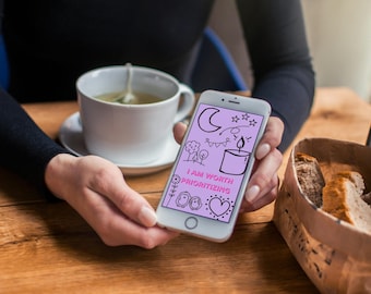 Może przedstawiać: Biały smartfon z jasnofioletowym ekranem, na którym widnieją czarne rysunki liniowe przedstawiające półksiężyc, gwiazdy, drzewa, świecę i serce oraz napis I AM WORTH PRIORITIZING pogrubionymi różowymi wielkimi literami.