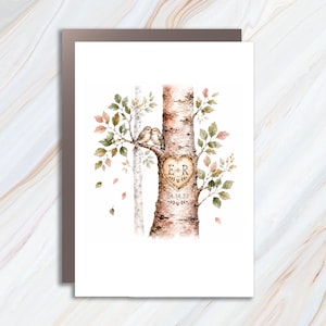 May include: A rectangular greeting card featuring a watercolor illustration of two birch trees with green and orange leaves. Two small birds sit on a branch. A heart is carved into the trunk with the letters E + R and the date 08.14.27 below it.