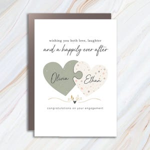 Tarjeta de compromiso personalizada con el mensaje "Les deseamos amor, risas y una vida feliz para siempre". Felicitaciones personalizadas para parejas. Rompecabezas Corazón WC45