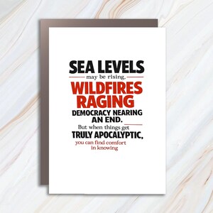 May include: A white greeting card with a brown border features black and red text. The text reads "SEA LEVELS may be rising, WILDFIRES RAGING DEMOCRACY NEARING AN END. But when things get TRULY APOCALYPTIC, you can find comfort in knowing."