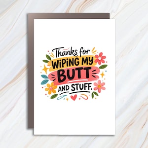 May include: A white greeting card featuring the phrase "Thanks for wiping my butt and stuff" in a colourful, playful font. The text is surrounded by floral and star illustrations in yellow, orange, and green.