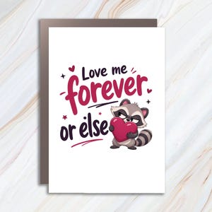 May include: A white greeting card featuring a cartoon raccoon with grey and black fur holding a large red heart. The text reads Love me forever or else in dark purple and red lettering, accented by small red hearts and star symbols.