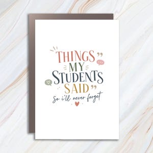 May include: A white greeting card featuring the text "THINGS MY STUDENTS SAID so i'll never forget" in multi-colored typography. The design includes small decorative speech bubbles, a heart icon, and quotation marks in shades of red, olive, and blue.