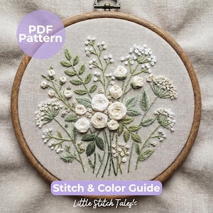Op de afbeelding: Een ronde houten borduurring met beige stof en een handgeborduurd bloemmotief van witte rozen en groen blad. De afbeelding bevat de tekst PDF Pattern en Stitch & Color Guide van Little Stitch Tales.