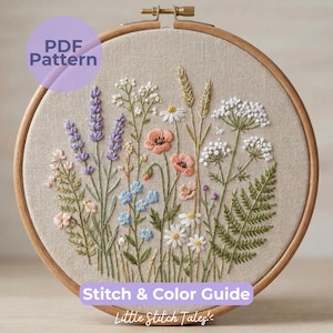 May include: An embroidered floral design in a wooden hoop. The artwork showcases a variety of wildflowers, including lavender, poppies, and daisies, in shades of pink, purple, white, and blue. The text "PDF Pattern" and "Stitch & Color Guide" are visible.